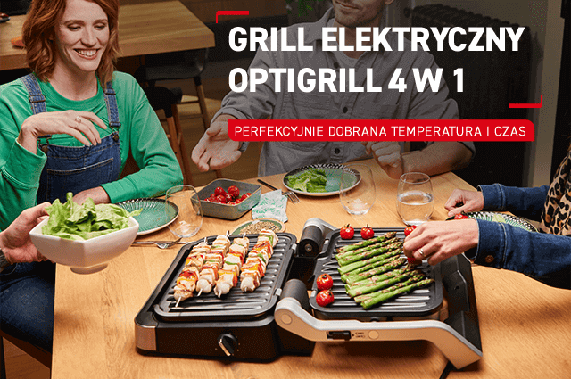 Na stole znajduje się grill elektryczny z potrawami, takimi jak szaszłyki i szparagi. Widoczny jest tekst: \'GRILL ELEKTRYCZNY OPTIGRILL 4W1\' oraz \'PERFEKCYJNIE DOBRANA TEMPERATURA I CZAS\'.