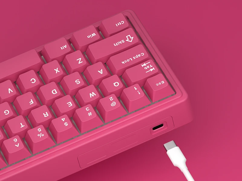 Różowa klawiatura z białymi oznaczeniami klawiszy, widoczny port USB-C oraz odłączony biały kabel.