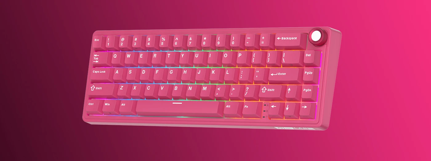 Klawiatura mechaniczna w kolorze różowym z podświetleniem RGB, posiada klawisze z oznaczeniami liter i symboli oraz pokrętło w prawym górnym rogu. Widoczne są klawisze takie jak \'Enter\', \'Shift\', \'Backspace\' oraz \'Ctrl\'.