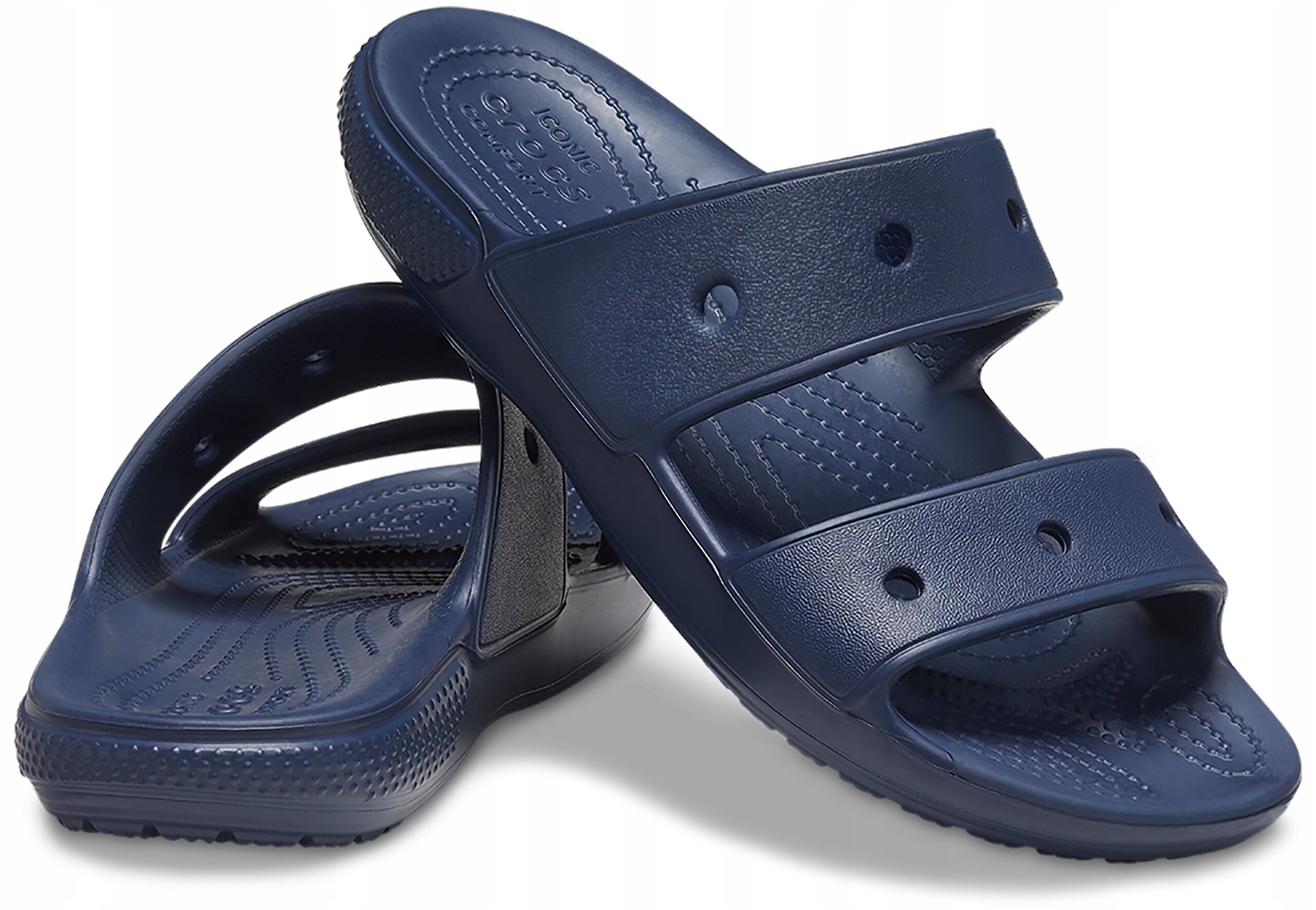 Na obrazie widoczne są granatowe klapki z dwoma paskami, wykonane z tworzywa sztucznego. Na jednym z pasków znajduje się wytłoczony napis \'Crocs\'.