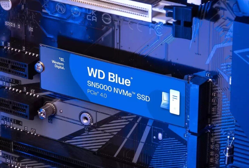 Na obrazie widoczny jest dysk SSD z napisem \'WD Blue SN5000 NVMe SSD PCIe 4.0\' zamontowany na płycie głównej. Logo producenta to \'Western Digital\'.