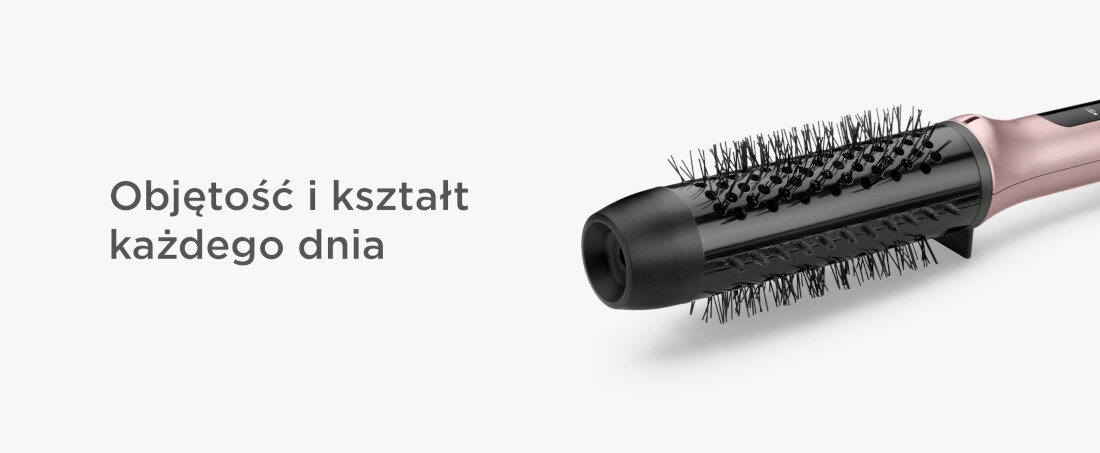 Na obrazie widoczna jest suszarko-lokówka z czarną szczotką i różowym uchwytem. Obok znajduje się tekst: \'Objętość i kształt każdego dnia\'.