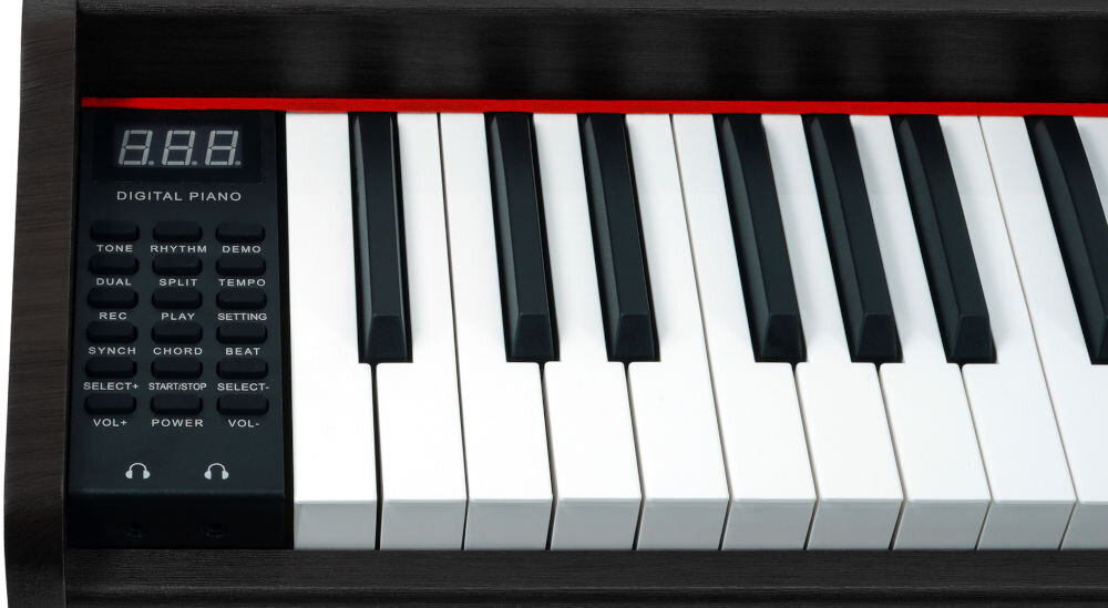 Obraz przedstawia fragment klawiatury pianina cyfrowego z widocznymi białymi i czarnymi klawiszami oraz panelem sterowania z wyświetlaczem LED i przyciskami oznaczonymi m.in. jako TONE, RHYTHM, DEMO, DUAL, SPLIT, TEMPO, REC, PLAY, SETTING, SYNC, CHORD, BEAT, START/STOP, SELECT-, SELECT+, VOL-, VOL+, POWER.