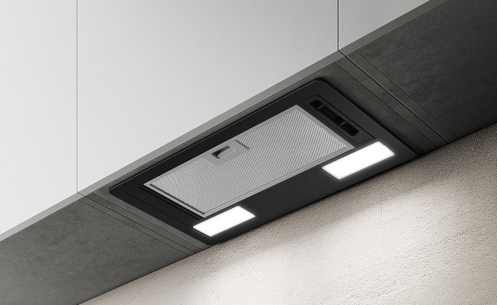Na obrazie widoczny jest szary okap kuchenny zamontowany pod szafką, z dwoma prostokątnymi światłami LED. Okap ma metalowy filtr i panel sterowania z przyciskami.