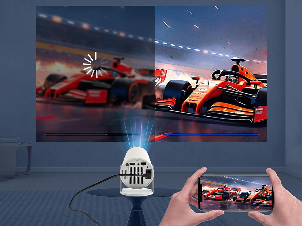 Na obrazie widać projektor wyświetlający obraz wyścigowego samochodu na ścianie. Obok projektora znajduje się smartfon z tym samym obrazem, a na ekranie widoczny jest symbol ładowania.