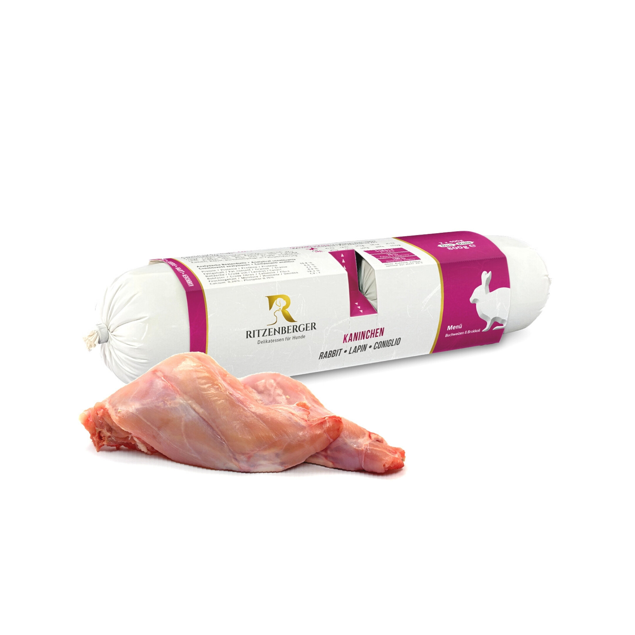 Na obrazie widoczna jest rolka karmy mokrej dla psa marki Ritzenberger z etykietą zawierającą napis \'KANINCHEN RABBIT LAPIN CONIGLIO\'. Obok rolki znajduje się kawałek surowego mięsa.