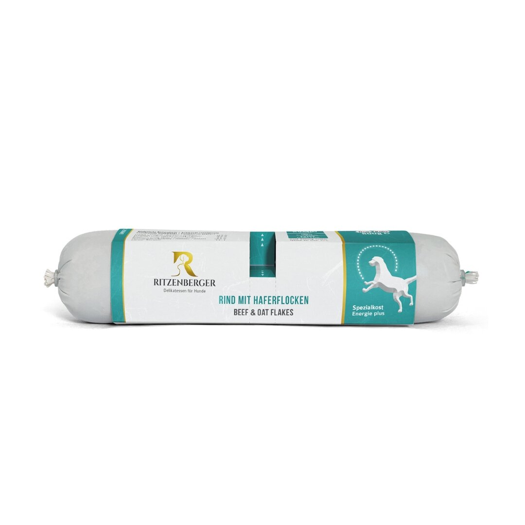 Opakowanie karmy dla psów marki Ritzenberger z napisem \'RIND MIT HAFERFLOCKEN BEEF & OAT FLAKES\'. Widoczne jest logo producenta oraz grafika psa na turkusowym tle.