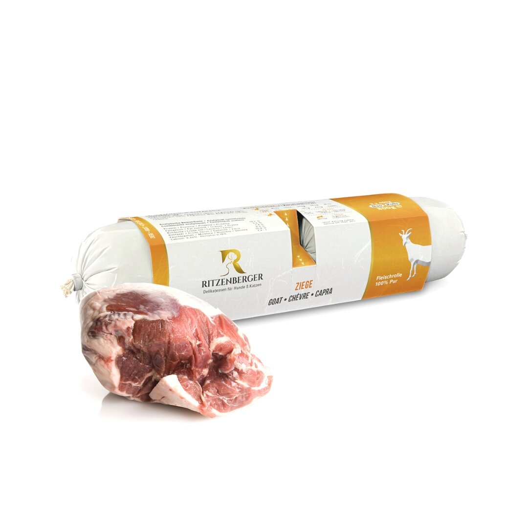 Na obrazie widoczna jest rolka karmy dla psa z logo RITZENBERGER oraz kawałek surowego mięsa. Opakowanie jest białe z pomarańczowym akcentem i napisem \'ZIEGE GOAT CHEVRE CAPRA\'.