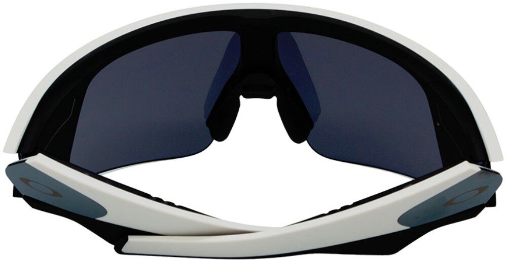 Okulary przeciwsłoneczne z białymi oprawkami i ciemnymi soczewkami, z widocznym logo Oakley na zausznikach.