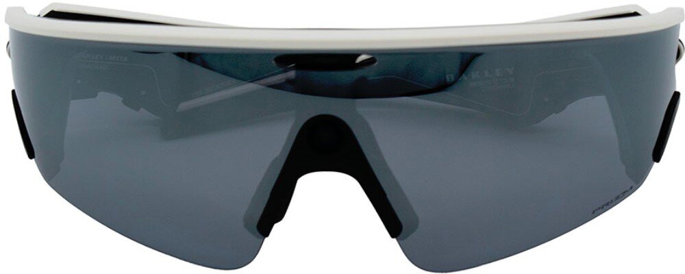 Okulary przeciwsłoneczne z ciemnymi szkłami i białą oprawką na górze. Na szkłach widoczne jest logo \'Oakley\'.
