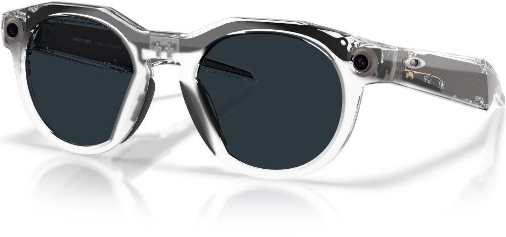 Przezroczyste okulary przeciwsłoneczne z ciemnymi soczewkami i wbudowanymi kamerami po bokach. Na zauszniku widoczne jest logo Oakley.