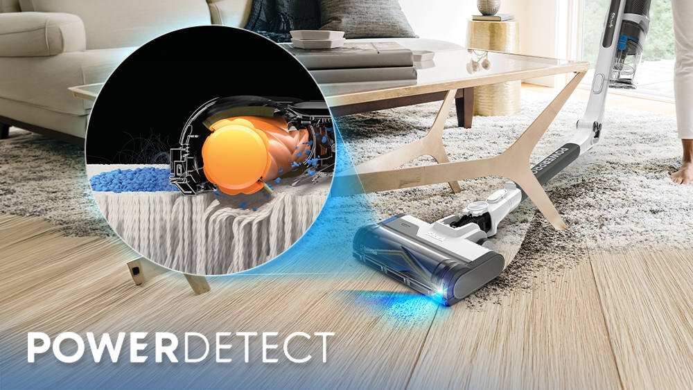 Odkurzacz z technologią PowerDetect odkurza dywan w salonie, a obok widoczny jest przekrój mechanizmu szczotki. Na podłodze widać drewniane panele i dywan, a w tle znajduje się stolik kawowy i sofa.
