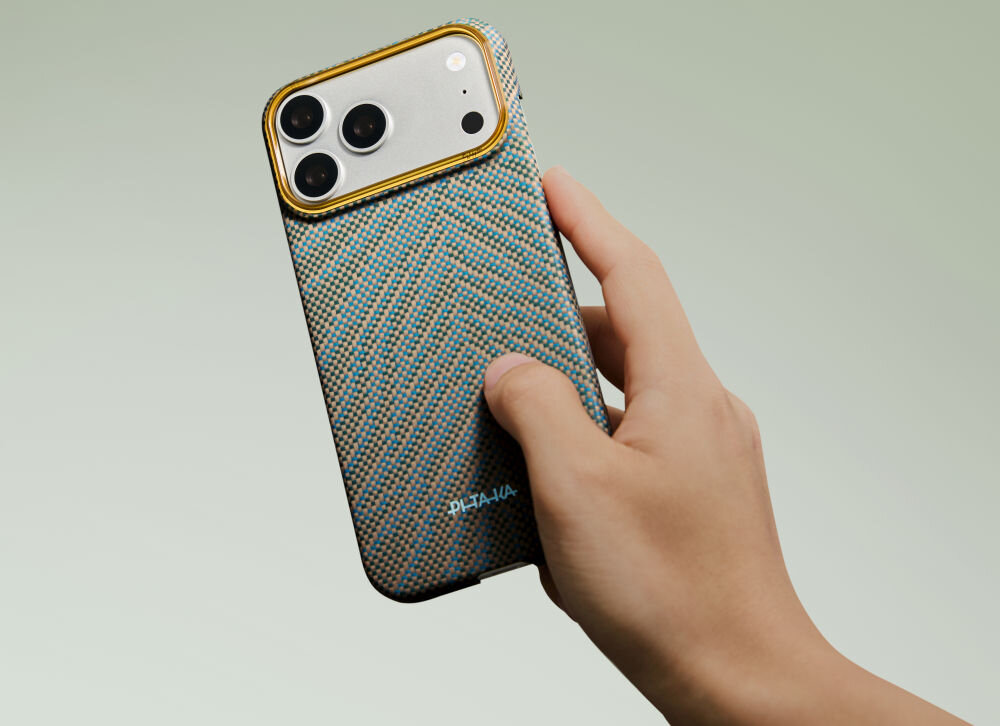 Osoba trzyma telefon w etui o wzorze w jodełkę z trzema widocznymi obiektywami aparatu. Na etui widoczny jest napis \'PITAKA\'.