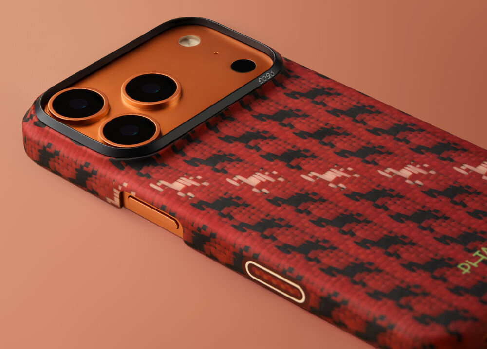 Etui na telefon z czerwono-czarnym wzorem, z trzema widocznymi obiektywami aparatu i pomarańczowymi elementami. Na etui widoczne jest logo \'PITAKA\'.