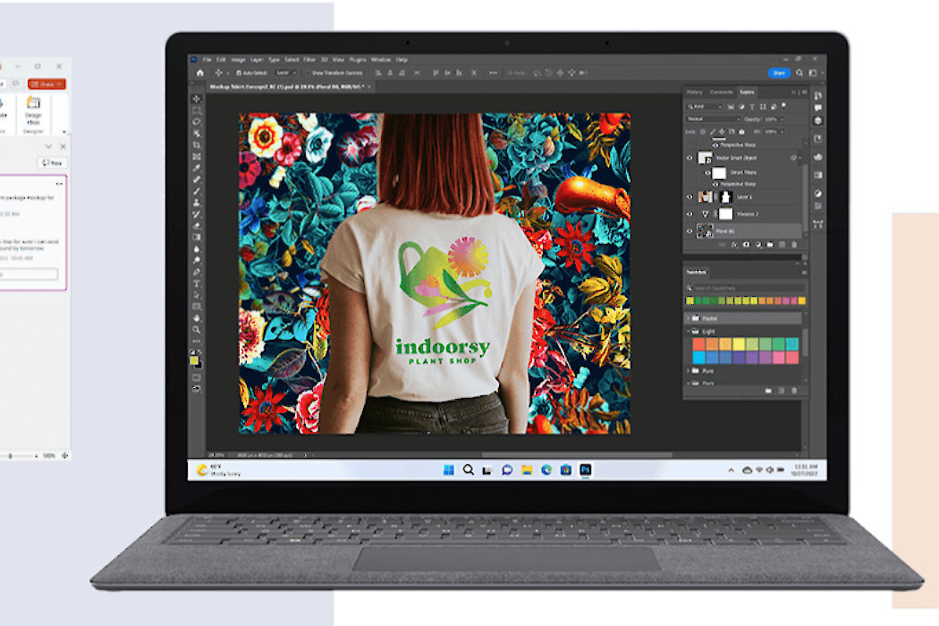 Laptop z wyświetlonym na ekranie programem graficznym, w którym widać osobę w koszulce z napisem \'indoorsy PLANT SHOP\' na tle kolorowych kwiatów. Na pasku zadań widoczne są ikony systemu Windows 11.