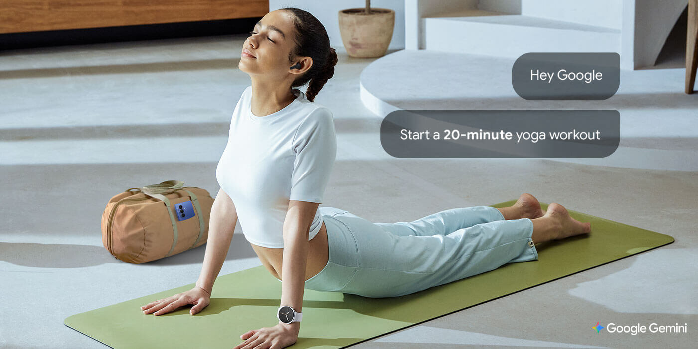 Kobieta z Galaxy Watch8 i słuchawkami Galaxy Buds3 FE rozciąga się na macie do jogi, mając obok siebie torbę sportową. Podczas rozciągania używa funkcji budzenia głosowego, aby aktywować Gemini, mówiąc „Hej Google” i prosząc o ustawienie timera. Osoba ćwiczy jogę na macie, obok znajduje się torba sportowa. Na obrazie widoczny jest tekst: \'Hey Google Start a 20-minute yoga workout\' oraz logo \'Google Gemini\'.