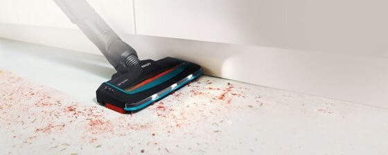 Odkurzacz z funkcją mopowania zbiera zanieczyszczenia z podłogi. Widoczne jest logo \'PHILIPS\' na urządzeniu.