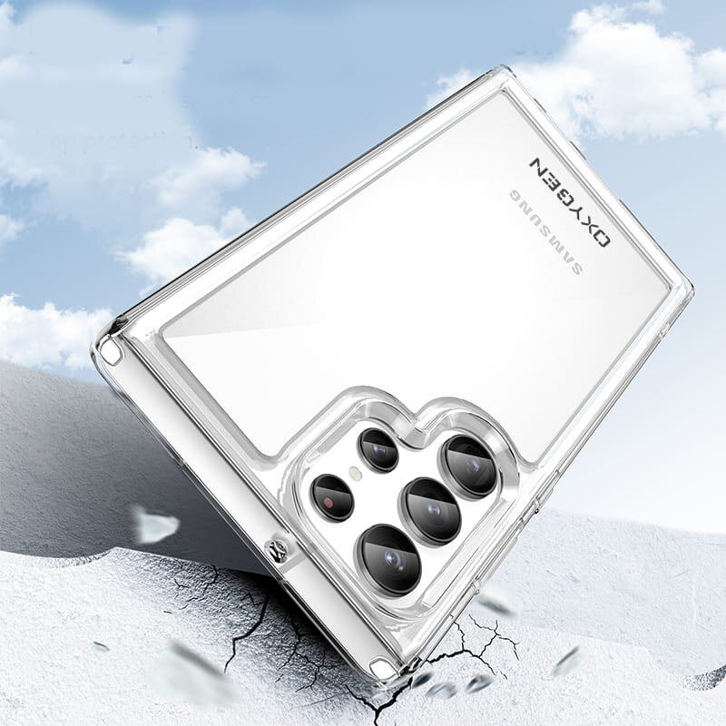Przezroczyste etui na telefon z widocznymi wycięciami na aparaty, leży na popękanej powierzchni. Na etui widoczne są napisy: \'OXYGEN\' i \'SAMSUNG\'.