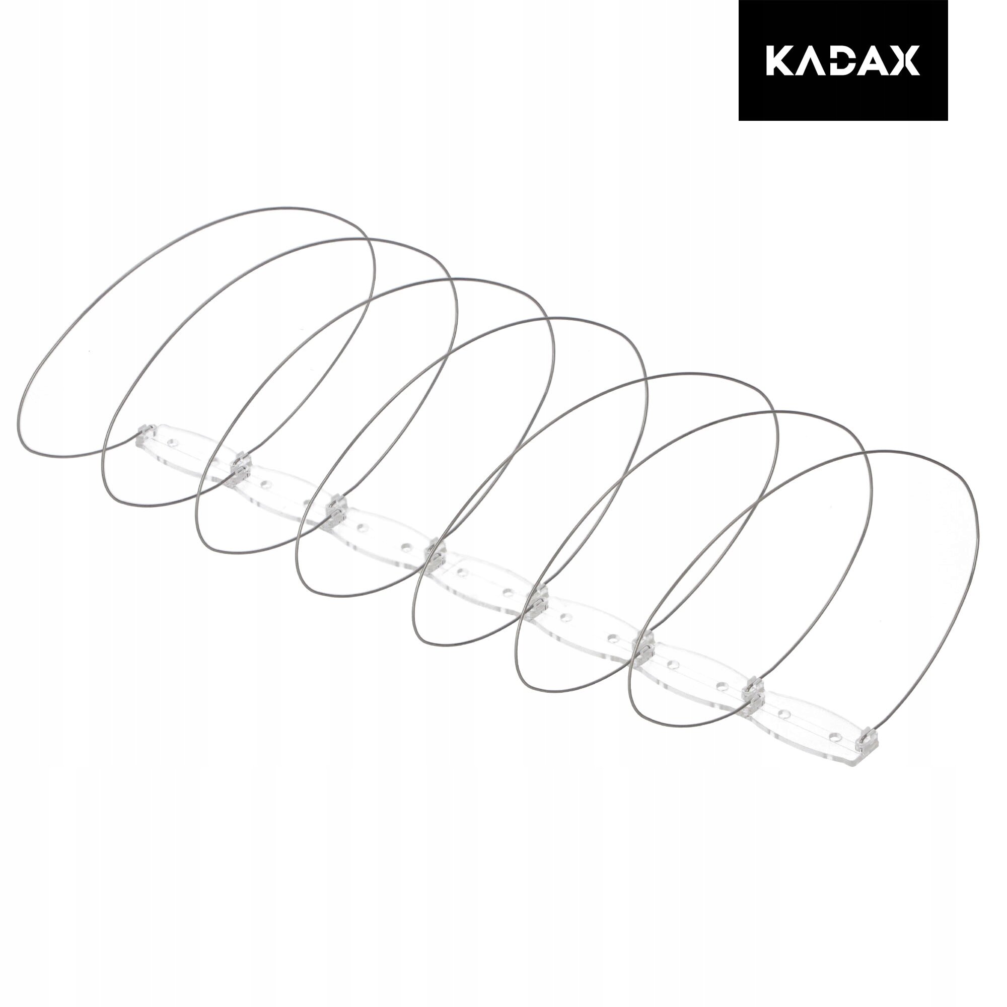 Na obrazie widoczne są metalowe spirale zamontowane na przezroczystej podstawie, służące jako kolce przeciw ptakom. W prawym górnym rogu znajduje się logo z napisem \'KADAX\'.