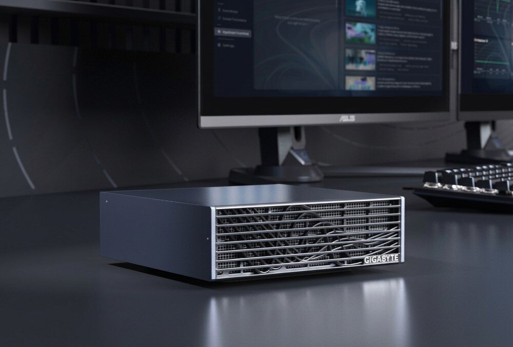 Komputer GIGABYTE AI Top Atom ARM Urządzenie z metalowym grillem chłodzącym na przednim panelu ustawione na ciemnym blacie