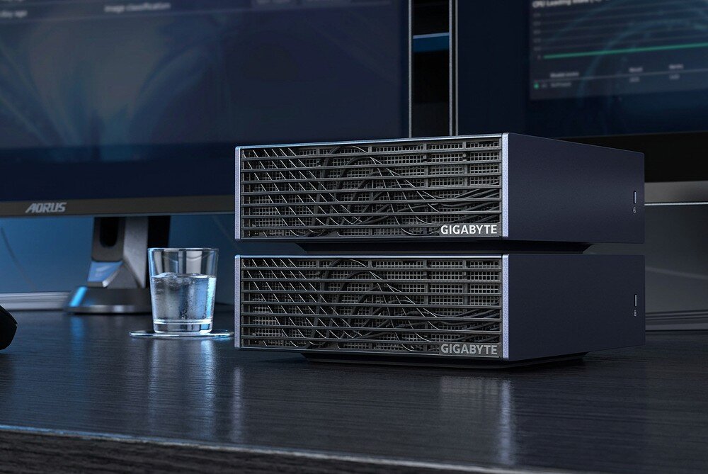 Komputer GIGABYTE AI Top Atom ARM Dwa identyczne, kompaktowe urządzenia komputerowe ułożone jedno na drugim na biurku