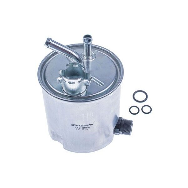 Na obrazie widoczny jest metalowy filtr paliwa z kilkoma wystającymi rurkami oraz trzema uszczelkami obok. Na filtrze znajduje się napis: \'DENCKERMANN A12 0956 FUEL FILTER\'.