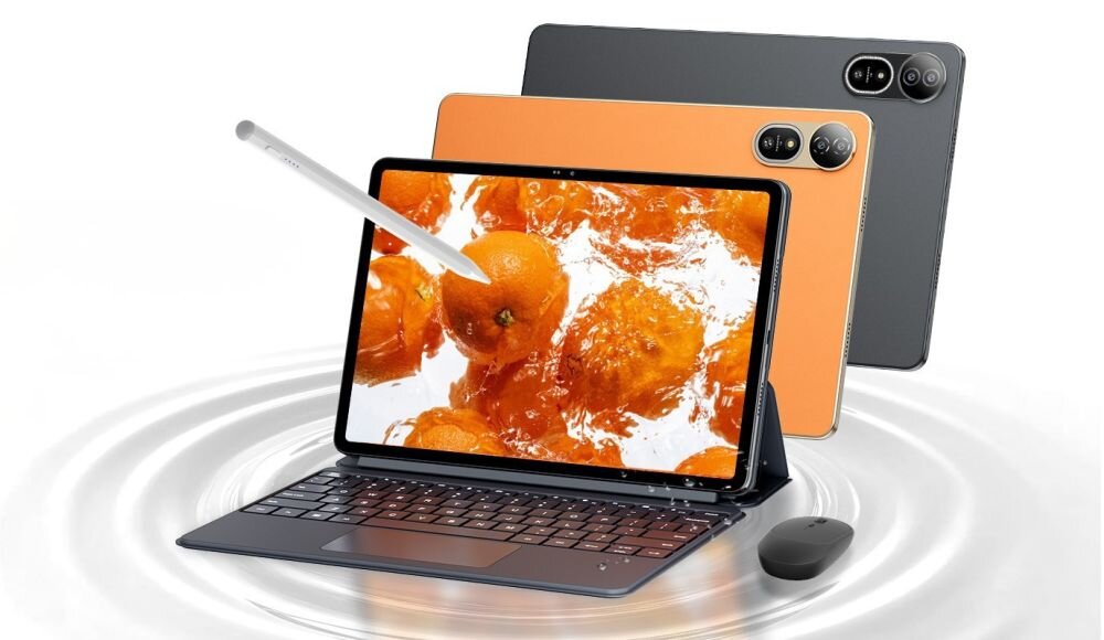 Na obrazie widoczny jest tablet z wyświetlaczem przedstawiającym pomarańcze w wodzie, obok którego znajduje się rysik, klawiatura i mysz. W tle widać dwa inne tablety w różnych kolorach.