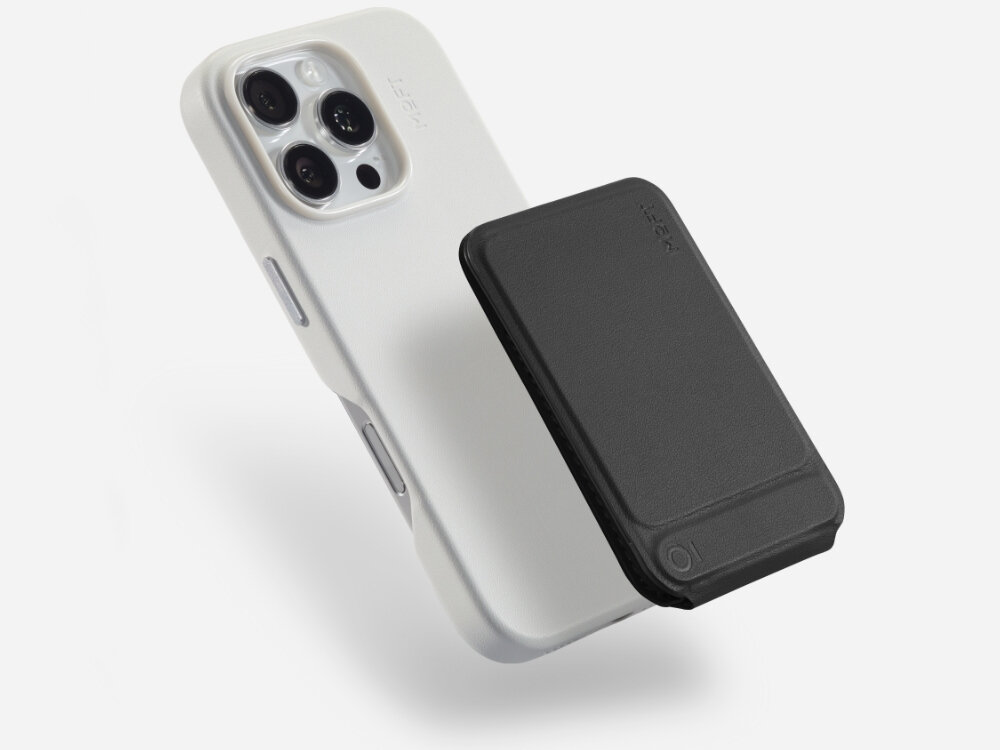 Na obrazie widoczny jest biały telefon z trzema obiektywami aparatu oraz czarny stojak magnetyczny przymocowany do jego tylnej części. Na stojaku widnieje logo \'MOFT\'.
