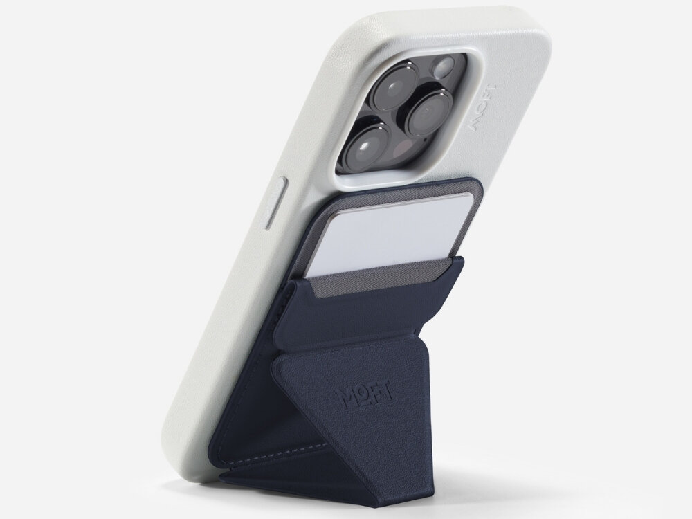 Na zdjęciu widać telefon w białym etui z granatowym portfelem MOFT Movas Snap-On MagSafe przymocowanym z tyłu. Portfel ma kieszeń na kartę i widoczne logo MOFT.