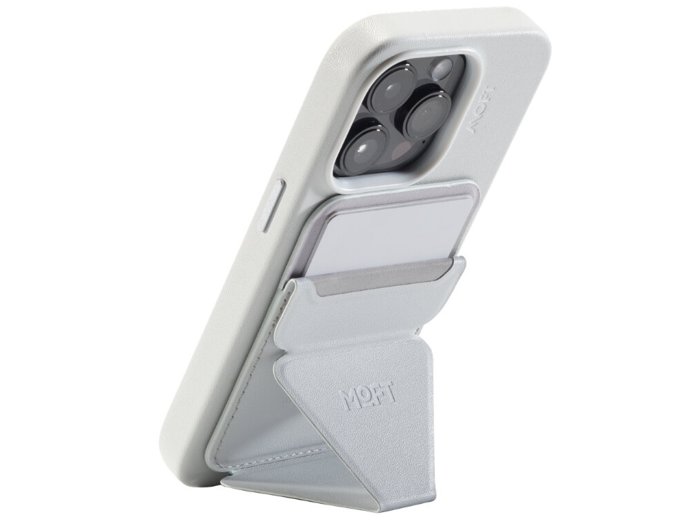 Szary portfel MOFT Movas Snap-On MagSafe przymocowany do tylnej części telefonu, z widocznym logo MOFT. Portfel pełni funkcję stojaka, a w jego wnętrzu znajduje się karta.