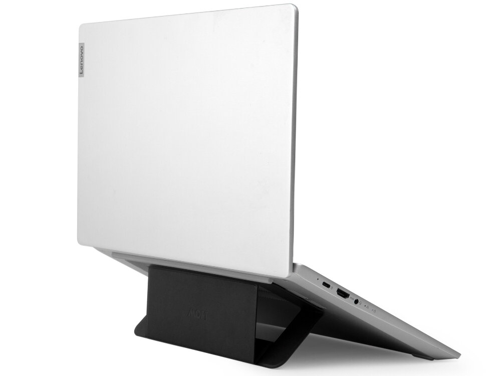 Na obrazie widoczny jest biały laptop ustawiony na czarnej podstawce. Na laptopie znajduje się logo \'Lenovo\', a na podstawce napis \'MOFT\'.
