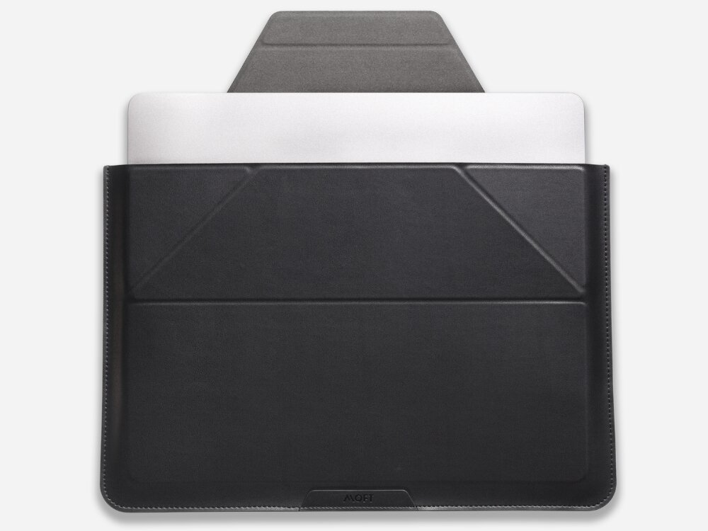 Czarna torba na laptopa z widocznym logo \'MOFT\' na dole, z wystającym białym laptopem. Torba ma prosty, elegancki design z geometrycznymi przeszyciami.