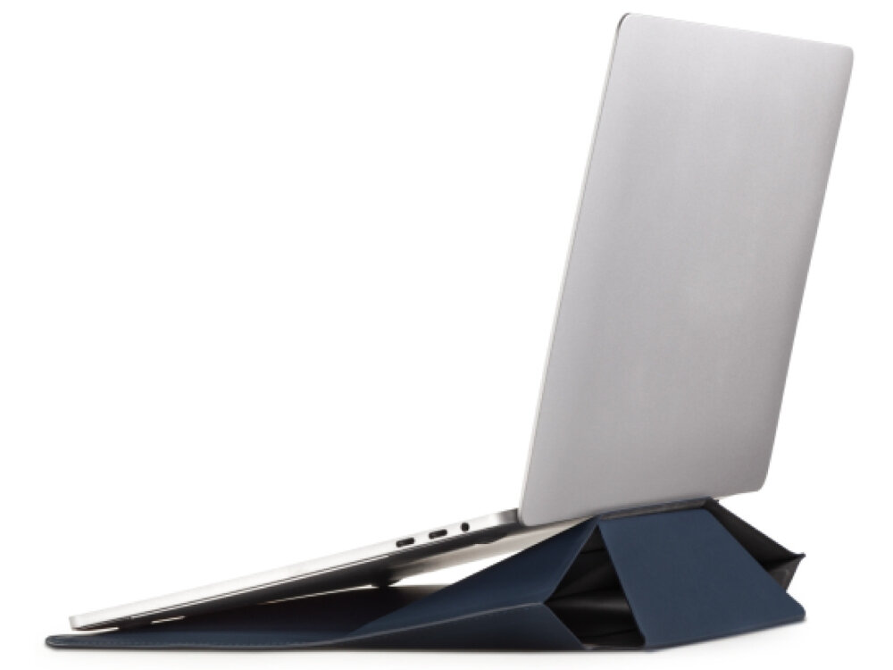 Na obrazie widać laptopa umieszczonego na niebieskiej podstawce, która jest złożona w formę trójkątną. Laptop jest otwarty, a jego ekran jest skierowany w górę.