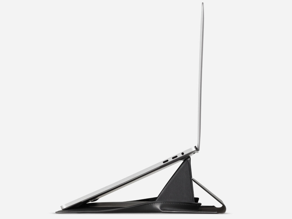 Na obrazie widoczny jest laptop ustawiony na czarnej podstawce, która unosi go pod kątem. Podstawka ma trójkątny kształt i jest zintegrowana z etui na laptopa.