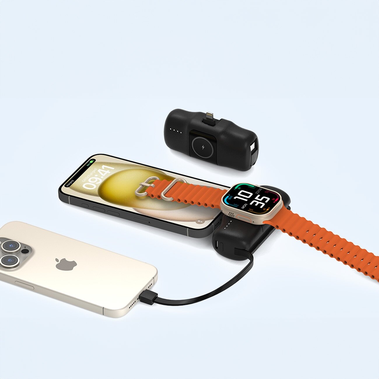 Na obrazie widoczny jest powerbank z funkcją ładowania bezprzewodowego, na którym umieszczony jest smartwatch z pomarańczowym paskiem. Obok znajduje się smartfon oraz drugi powerbank z widocznymi diodami LED.