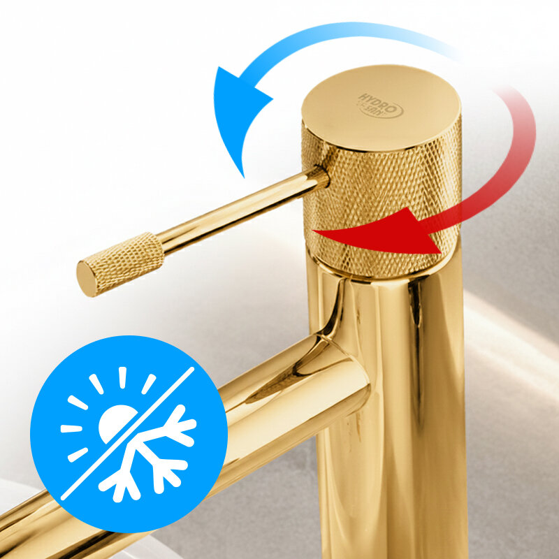 Złota bateria umywalkowa z widocznym logo \'HYDRO\'. Na baterii znajdują się niebieska i czerwona strzałka wskazujące kierunek obrotu oraz niebieska ikona z symbolem słońca i płatka śniegu.