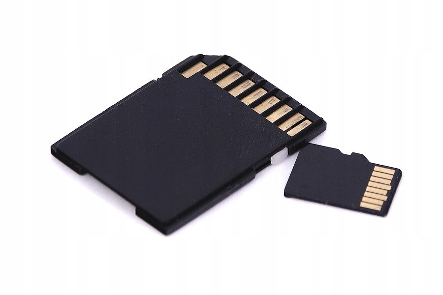 Na obrazie widoczna jest czarna karta Micro SD oraz większy adapter z widocznymi złotymi stykami.