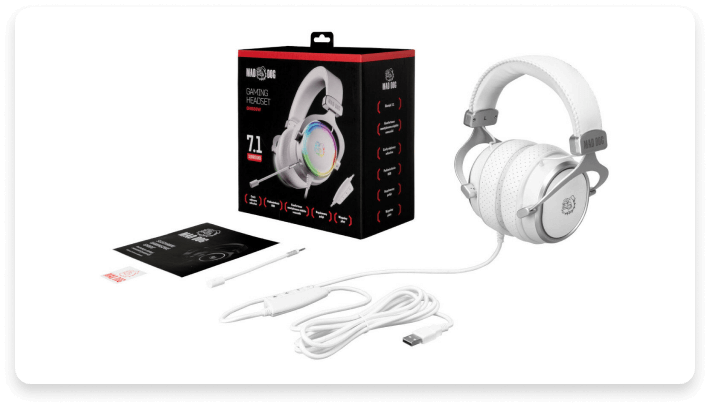 Na obrazie widoczne są białe słuchawki nauszne z mikrofonem oraz czarne pudełko z napisem \'MAD DOG GAMING HEADSET 7.1\'. Obok znajdują się przewód USB, instrukcja oraz karta gwarancyjna.
