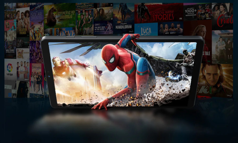 Tablet wyświetla dynamiczną scenę z filmu z postacią w czerwono-niebieskim kostiumie. W tle widoczne są miniatury różnych filmów i seriali.