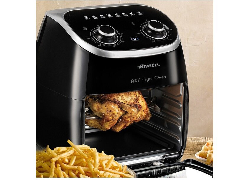 Czarna frytkownica beztłuszczowa z logo \'Ariete\' i napisem \'AIRY Fryer Oven\' na panelu. Wewnątrz urządzenia znajduje się pieczony kurczak, a obok leżą frytki.
