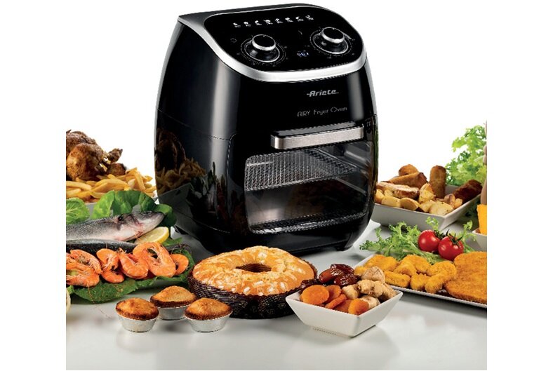 Czarna frytkownica beztłuszczowa z widocznym logo \'Ariete\' i napisem \'Air Fryer Oven\'. Wokół urządzenia znajdują się różnorodne potrawy, takie jak ryby, krewetki, ciasta i warzywa.
