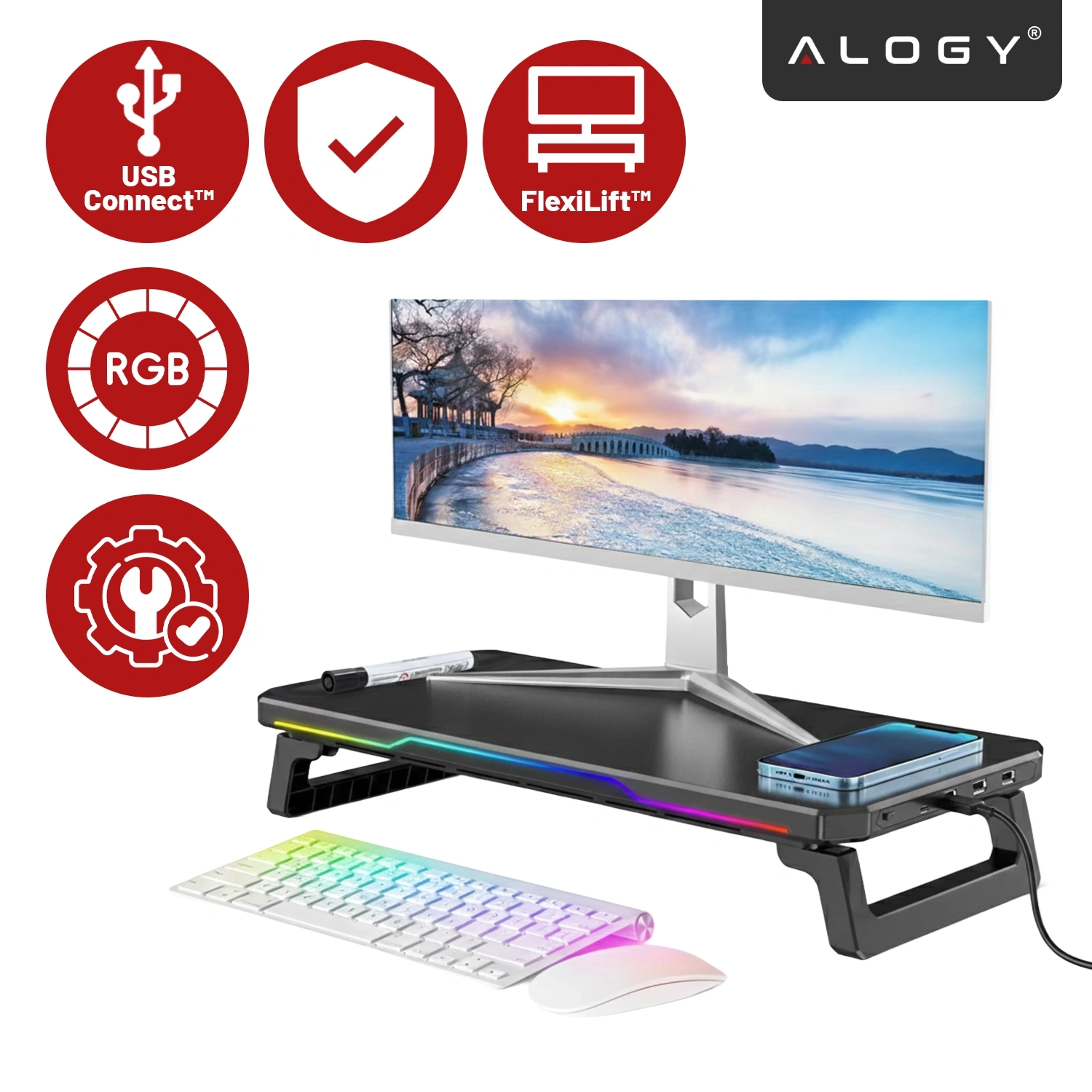 Na obrazie widoczna jest czarna podstawka pod monitor z oświetleniem RGB, na której znajduje się monitor, telefon i długopis. Obok znajdują się czerwone ikony z napisami: \'USB Connect™\', \'FlexiLift™\', \'RGB\'.