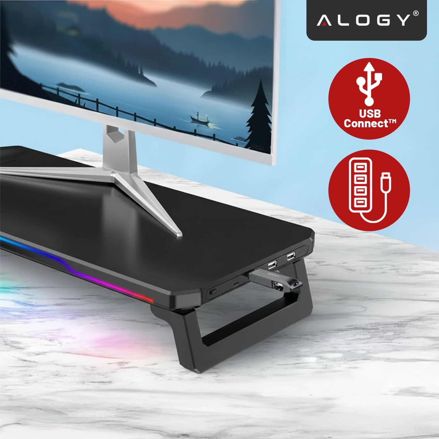 Na obrazie widać czarną podstawkę pod monitor z oświetleniem RGB, na której stoi monitor z krajobrazem jeziora. Obok znajduje się logo \'ALOGY\' oraz ikona z napisem \'USB Connect™\'.