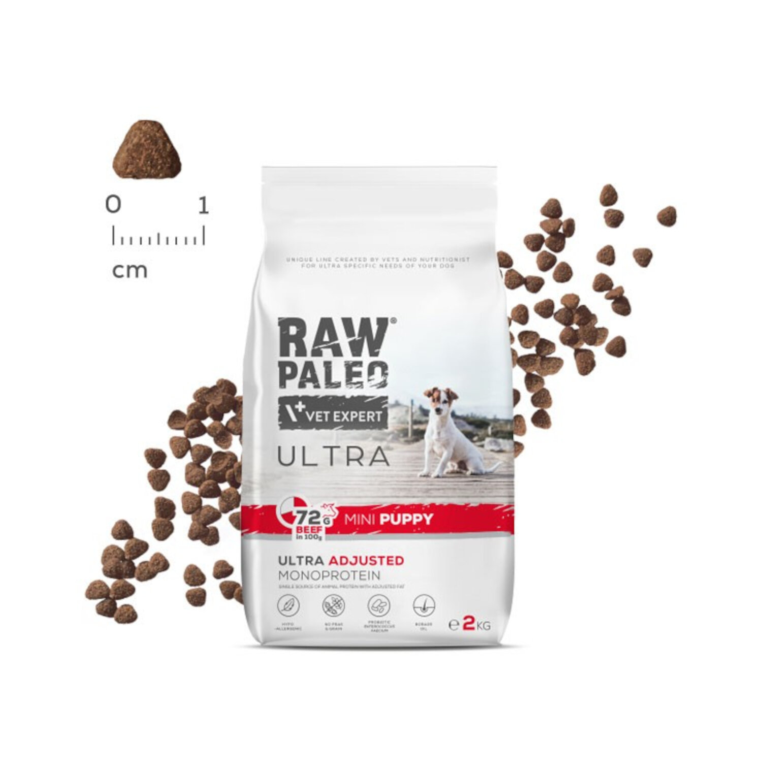 Opakowanie suchej karmy dla szczeniąt z wołowiną, z napisem \'RAW PALEO VET EXPERT ULTRA\'. Obok opakowania widoczne są granulki karmy oraz miarka w centymetrach.