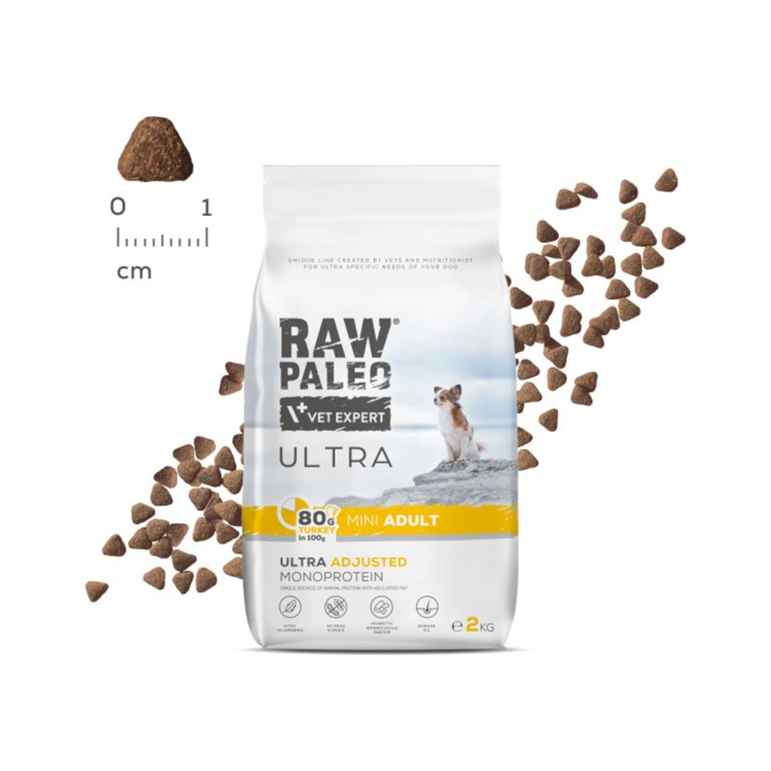 Opakowanie suchej karmy dla psów z napisem \'RAW PALEO VET EXPERT ULTRA MINI ADULT\'. Obok widoczna jest miarka w centymetrach oraz rozsypane granulki karmy.