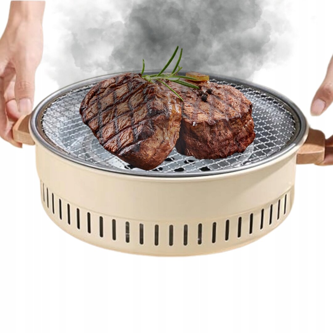 Przenośny grill turystyczny z dwoma kawałkami grillowanego mięsa na ruszcie, z unoszącym się dymem. Grill ma okrągły kształt i jasny kolor z drewnianymi uchwytami.