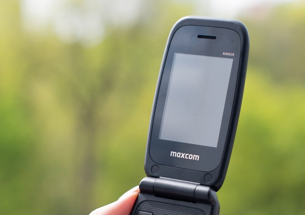 Telefon z klapką w kolorze niebieskim z widocznym logo \'maxcom\' i oznaczeniem modelu \'MM828\'.