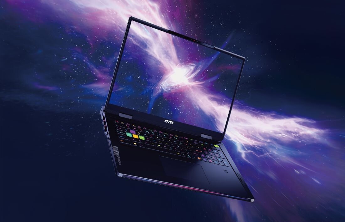 Laptop z logo \'msi\' na obudowie, z kolorową klawiaturą, wyświetla na ekranie dynamiczną grafikę przypominającą kosmos. Tło jest ciemne z jasnymi, rozmytymi smugami światła.