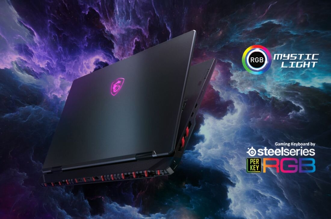 Laptop z podświetlanym logo na tle kolorowej, kosmicznej grafiki. Widoczne napisy: \'RGB Mystic Light\' oraz \'Gaming Keyboard by Steelseries Per Key RGB\'.