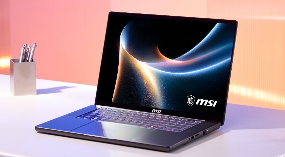 Laptop MSI Stealth stoi na biurku, prezentując smukłą konstrukcję i podświetlaną klawiaturę podczas codziennej pracy i rozrywki